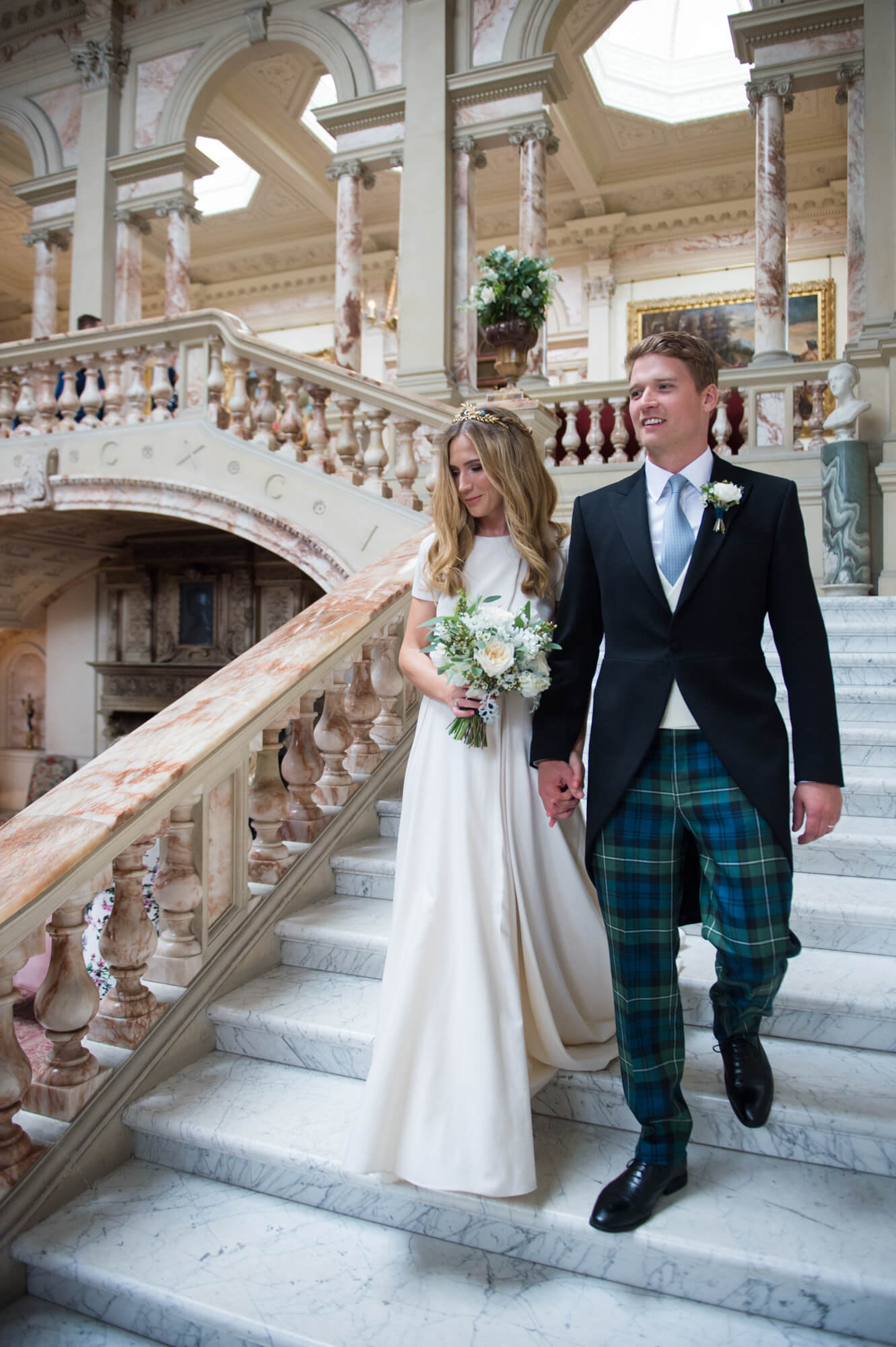 A bride and groom walking down the steps at Gosford House in Scotland